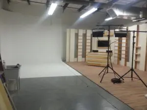 A photo studio with lights and a white backdrop.