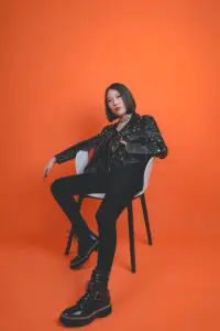 A woman sitting on top of a white chair.