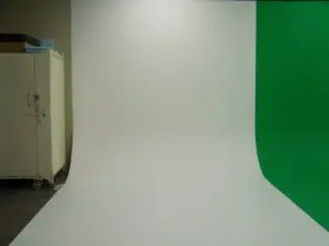 A green screen and white backdrop in a room.