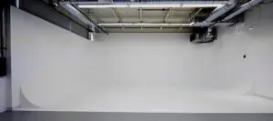 A white wall with two lights on the ceiling.